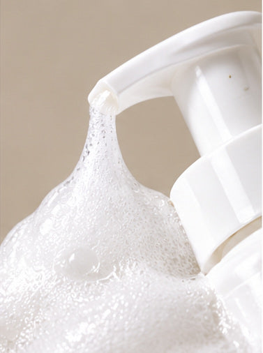 Foaming cleanser pump nozzle and cream-like foam close-up